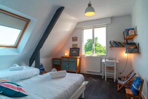Un dormitorio abuhardillado con dos camas y una ventana. en Ti Ar Mor Braz- Maison avec grand jardin, en Saint-Philibert