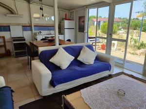 a living room with a blue couch and a kitchen at Quinta do Sol in Lagos
