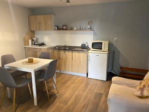 a small kitchen with a table and a microwave at Rebeka Panzió in Tihany