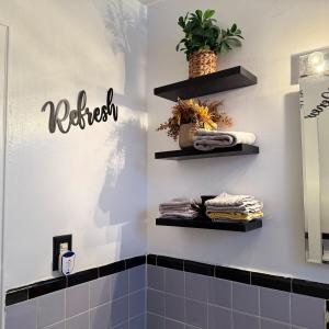 a bathroom with black shelves on the wall at Welcome to New Rochelle Studio in New Rochelle