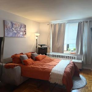 a bedroom with a bed with orange pillows and a window at Welcome to New Rochelle Studio in New Rochelle +19 photos