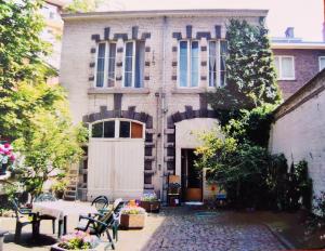 a building with a white door and a table and chairs at Le Piercot in Liège