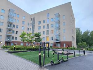 Un parque infantil con dos patinetes delante de un edificio. en Viherpihan helmi, en Espoo
