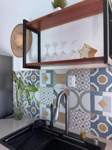 a kitchen sink with glasses on a tile wall at Coronaditos 2-Bedroom Appartment in Colonos in Valladolid