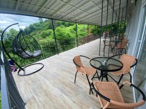 a balcony with a table and chairs and a swing at andiria in Gonio