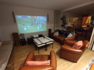 a living room with a tv and a large screen at Face a la mer in Courseulles-sur-Mer