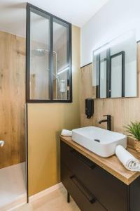 a bathroom with a white sink and a shower at Chamalières Appartement moderne pour 5 personnes in Chamalières