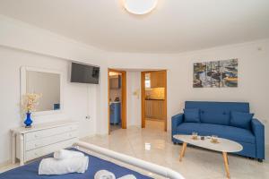 a living room with a blue couch and a table at Irene Luxury Apartments in Metaxáta