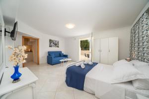 a bedroom with a bed and a blue chair at Irene Luxury Apartments in Metaxáta