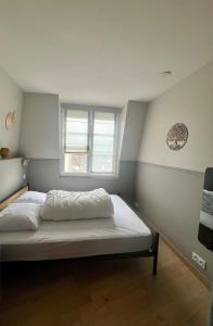a bedroom with a bed with white sheets and a window at Le Nid Marin, Cayeux-sur-Mer, Baie de Somme in Cayeux-sur-Mer