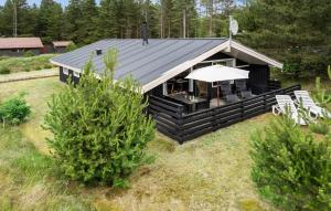 a log cabin with a table and an umbrella at Holiday Home Hedevej Xii Denmk in Ho +16 photos