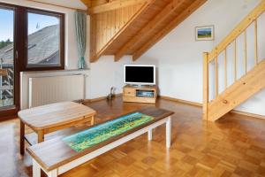 a living room with a table and a tv at Fewo Cheny mit Hochschwarzwaldcard in Titisee-Neustadt