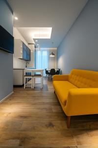 a living room with a yellow couch and a table at Case Vacanze 106 Maison De Charme in Giovinazzo +15 photos