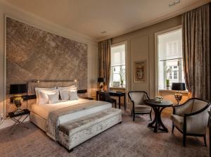 華沙的住宿－貝洛托酒店，卧室配有一张床和一张桌子及椅子