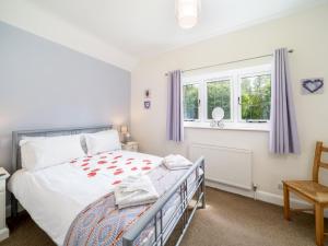 ein Schlafzimmer mit einem Bett und zwei Fenstern in der Unterkunft Chilterns Farm Cottage Hideaway Pass the Keys in Little Missenden