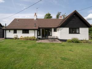 ein weißes Haus mit einem Tisch und Stühlen im Hof in der Unterkunft Chilterns Farm Cottage Hideaway Pass the Keys in Little Missenden