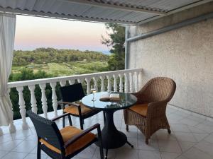 a balcony with a table and chairs and a view at Apartments Elena & Damir in Vis