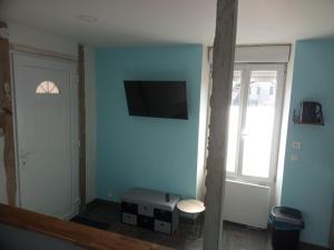 a room with a blue wall with a flat screen tv at Studio thème Oléron à Valdivienne in Cubord