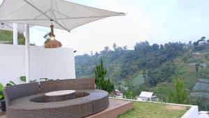 a patio with a white umbrella and a bench at Mahkota Sangkuriang Bandung in Bandung +104 photos