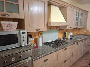 a kitchen with a microwave and a stove at Casa Antonia in Vecchiano