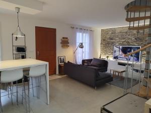 a living room with a black couch and a tv at Maison Hendaye Plage in Hendaye