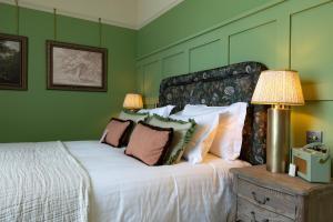 ein Schlafzimmer mit einem weißen Bett mit grünen Wänden in der Unterkunft The Ragged Robin - A Heartwood Inn in Godalming