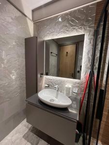 un baño con lavabo y espejo en The Diamond In City Luxury Suites By ZENORA Living, en Accra