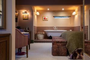 ein Badezimmer mit Bett und Badewanne in der Unterkunft The Ragged Robin - A Heartwood Inn in Godalming
