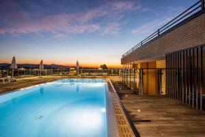 a large swimming pool next to a building at Grand Hotel Forlì in Forlì