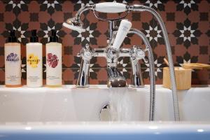 ein Waschbecken mit einem Wasserhahn und Seife in der Unterkunft The Ragged Robin - A Heartwood Inn in Godalming