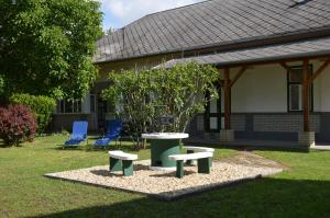 une table, deux chaises et un arbre dans la cour dans l'établissement Tisza-Kert Apartmanok, à Tiszafüred
