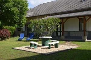 una mesa y dos sillas y un árbol en un patio en Tisza-Kert Apartmanok, en Tiszafüred