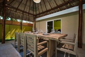 Un comedor con mesa y sillas de madera. en Luxury Villa with Pool Hidden Gem by Bocobay, en Palm-Eagle Beach