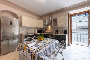 una cocina con una mesa y un refrigerador en Casa di Bruna, en Atrani