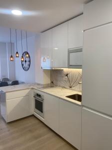 a kitchen with white cabinets and a sink at Oasis de Paz Cullera in Cullera