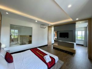 Un dormitorio con una cama grande y un televisor de pantalla plana. en Ruby Villa, en Nha Trang