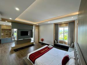 Un dormitorio con una cama grande y un televisor de pantalla plana. en Ruby Villa, en Nha Trang