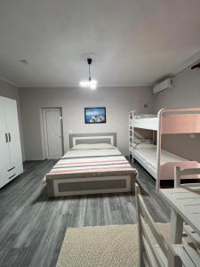 a bedroom with two beds and two bunk beds at Qetësia Borsh in Borsh
