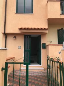 ein Gebäude mit einer grünen Tür und einem Zaun in der Unterkunft Appartamento Bellavista in Roccella Ionica
