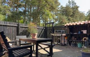 a patio with a table and chairs and a grill at Amazing Home In Aakirkeby With Wifi in Vester Sømarken