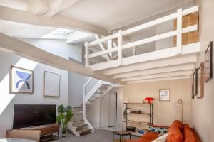 a loft apartment with a staircase and a living room at Le Post-Rétro, hyper centre, avec parking gratuit et ascenseur in Angoulême