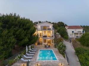 an aerial view of a house with a swimming pool at Spacious new villa with pool above the pristine beach - FIRST SEASON PRICING!!! in Prvić Šepurine