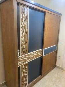 a wooden door with a glass and metal design on it at استيلا هايتس الساحل الشمالي in Dawwār ‘Abd al Qādir Qāsim