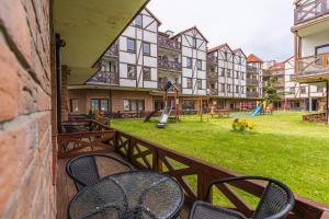 a balcony with chairs and a playground in a building at Apartamenty Zefir in Rowy
