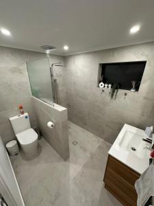 a bathroom with a toilet and a sink and a tv at Central Cullen Wagga Apartments in Wagga Wagga +98 photos