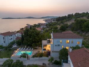 an aerial view of a house with a swimming pool at Spacious new villa with pool above the pristine beach - FIRST SEASON PRICING!!! in Prvić Šepurine