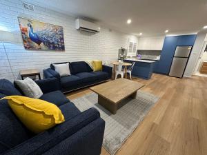 a living room with a blue couch and a table at Central Cullen Wagga Apartments in Wagga Wagga