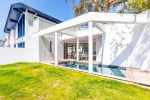 a white house with a pool in the yard at Villa Baroya - Villa piscine proche des plages in Bidart