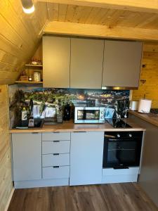 a kitchen with white cabinets and a stove at Cottage MIRNI RAJ in Jajce +19 photos
