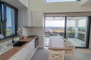 a kitchen with a large window and a table with chairs at Villa Amelia by Travel Pro - Mouries Halkidiki in Paralia Dionysiou